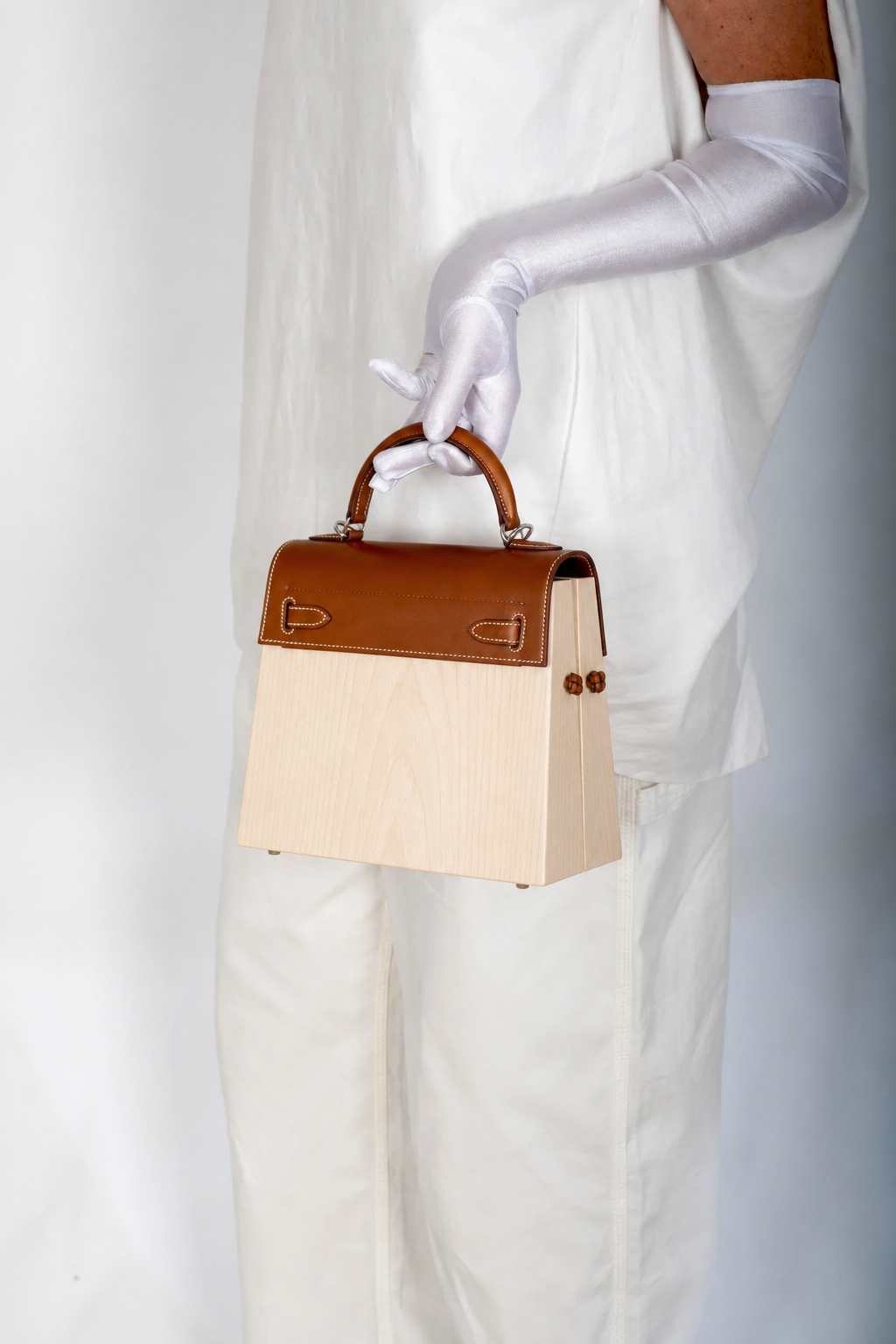 Hermès Kelly Kellywood studio model shot, rear three-quarter showing plain natural wood back and sides