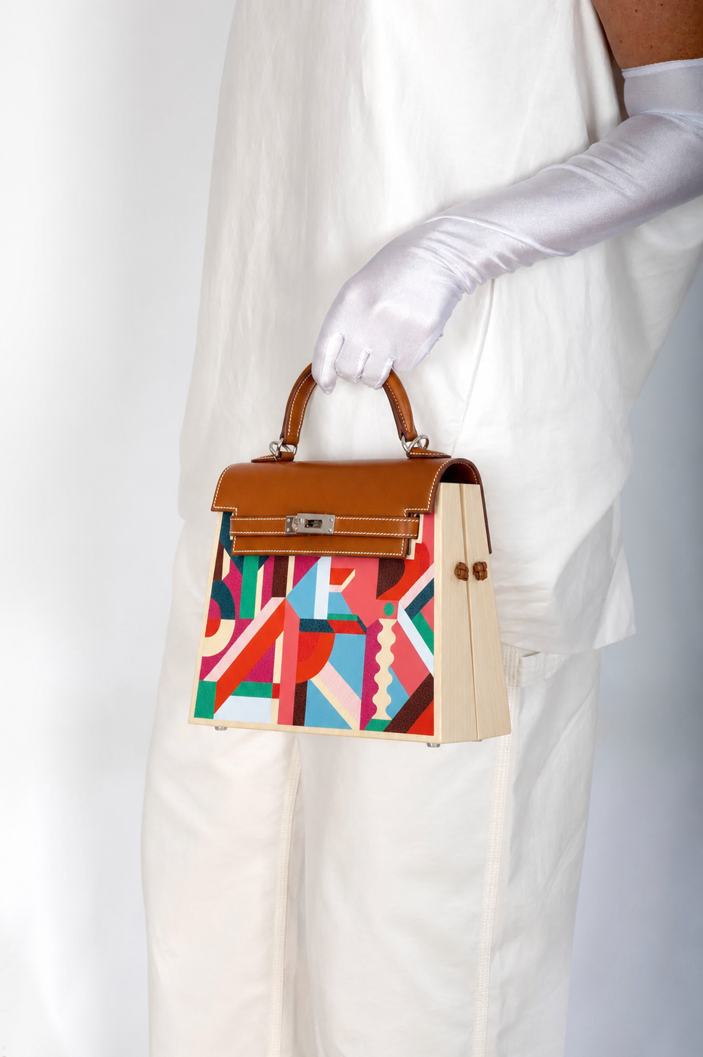 Hermès Kelly Kellywood studio model shot, hand-held front three-quarter with natural wood side panels